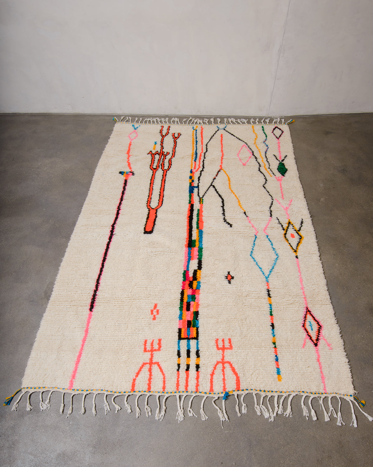 Berberlin Azilal rug made of fluffy wool and colourful cotton, laying flat on a concrete floor.